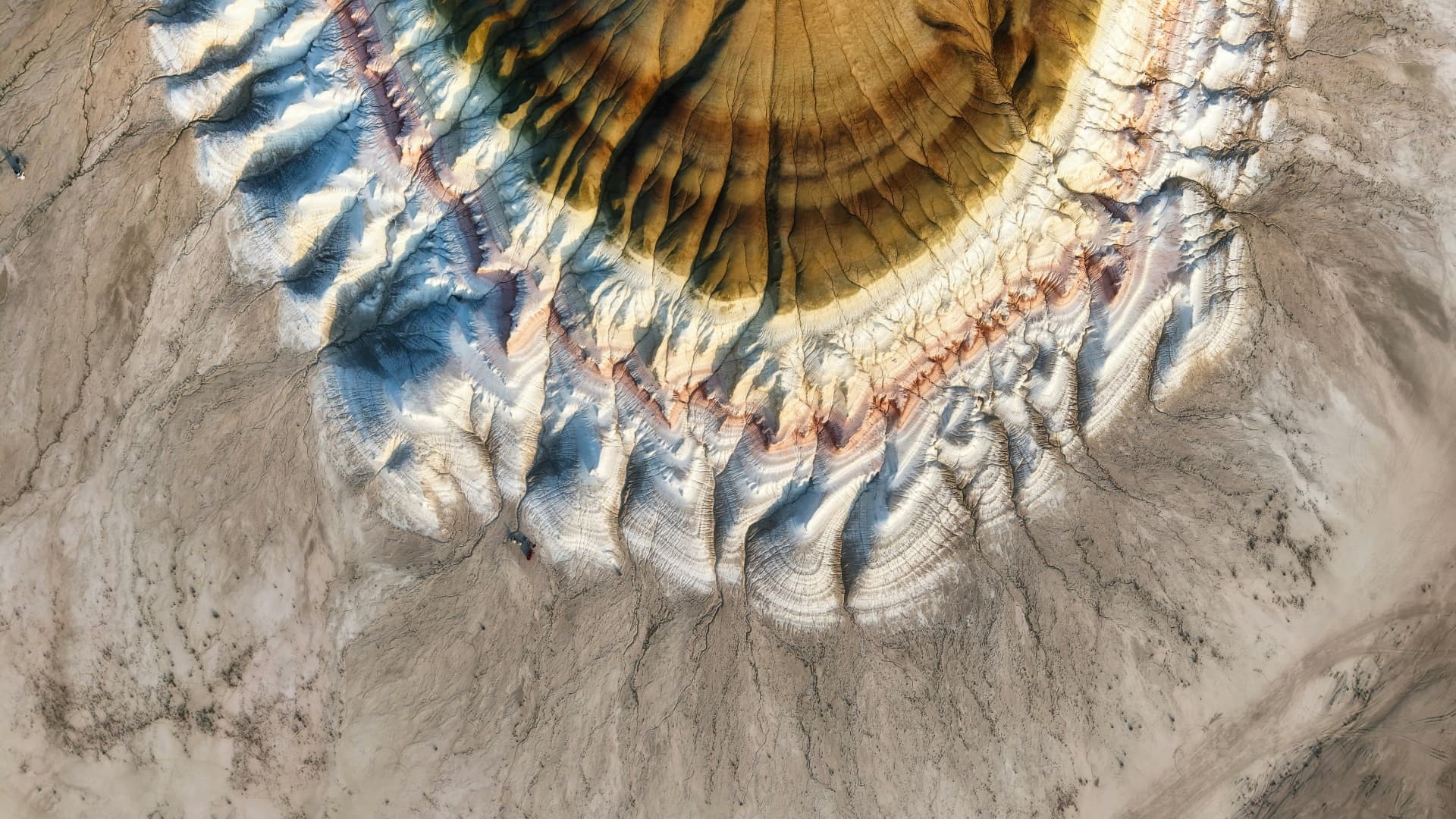 Cirkulær geologisk formation med blå og gyldne lag set ovenfra